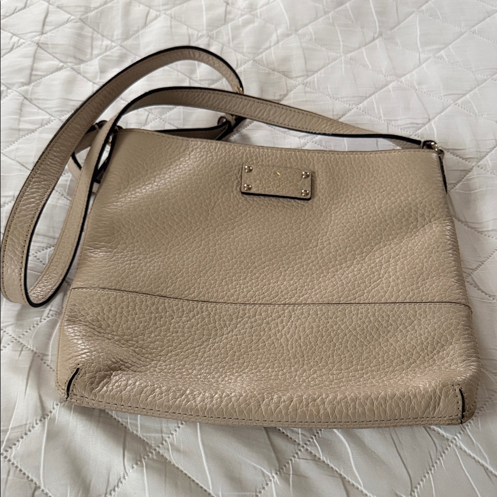 Kate Spade cream colored crossbody with adjustable strap.